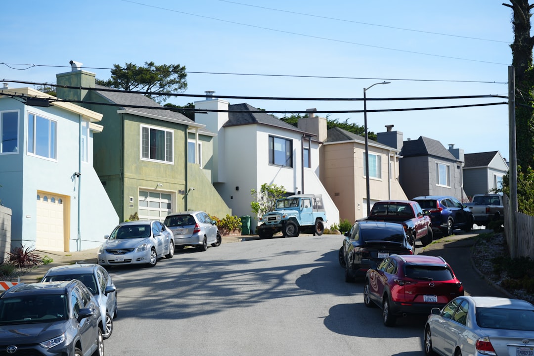 Cars parked on a residential street with houses.