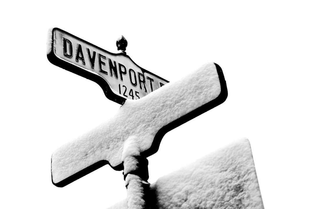 a black and white photo of a street sign covered in snow