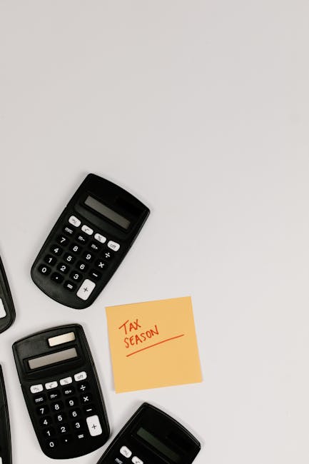 Black calculators on a white background with a yellow sticky note saying 'Tax Season'.