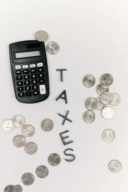 Calculator and scattered coins with the word 'TAXES' on a white background.