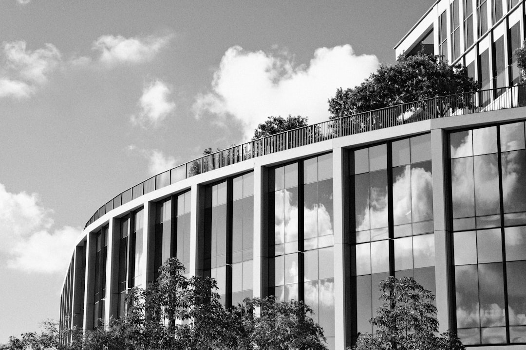 Modern building with reflective glass windows and trees.