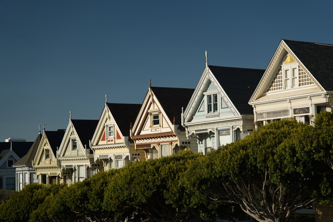 Painted ladies victorian homes line up on a hill.